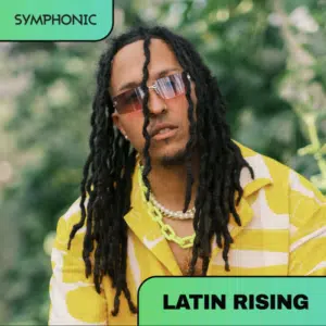 Man with long dreadlocks, sunglasses, and a yellow patterned shirt poses outdoors. The image has "SYMPHONIC" and "LATIN RISING" text banners in the corners.